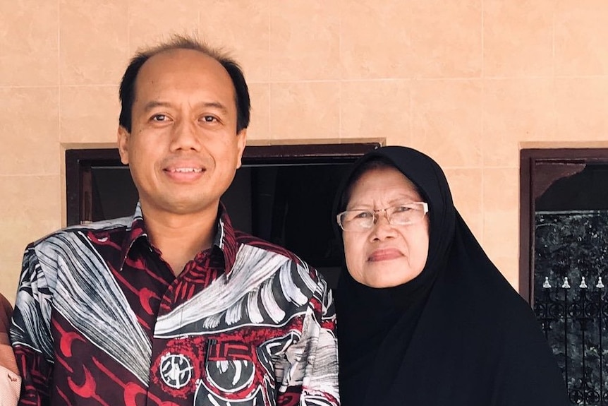 Sutopo Nugroho stands next to his mother