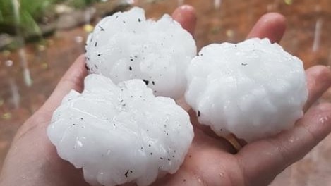 Three large hailstones are held after a storm in Sydney.