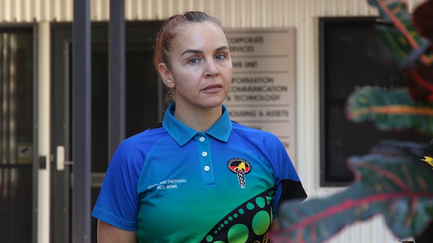A woman in a colourful shirt looking at the camera