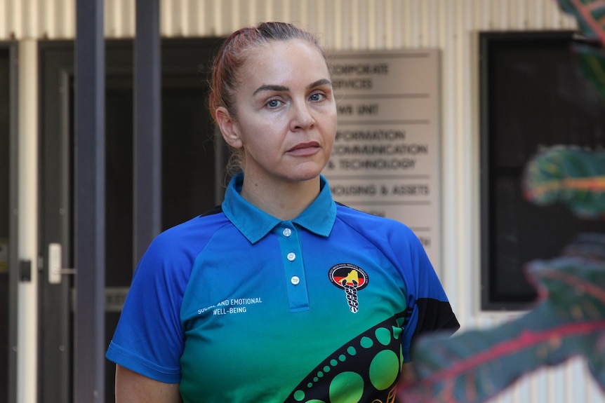 A woman in a colourful shirt looking at the camera
