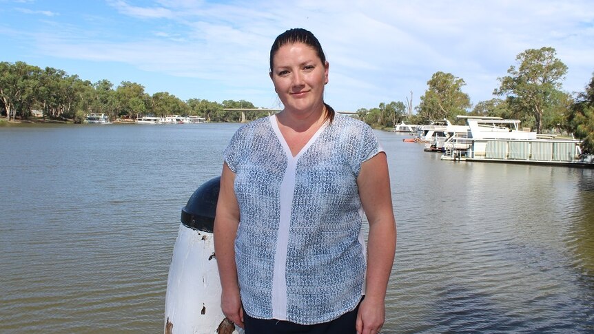 A woman stands beside the Murray River in country Victoria.