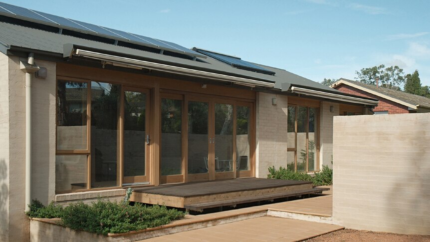 Ex-govie house from the 1960s after renovation, to include solar panels, wide glass panelled doors and rendered brick
