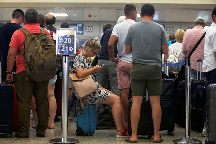 Thomas Cook passengers queue up in a check-in service