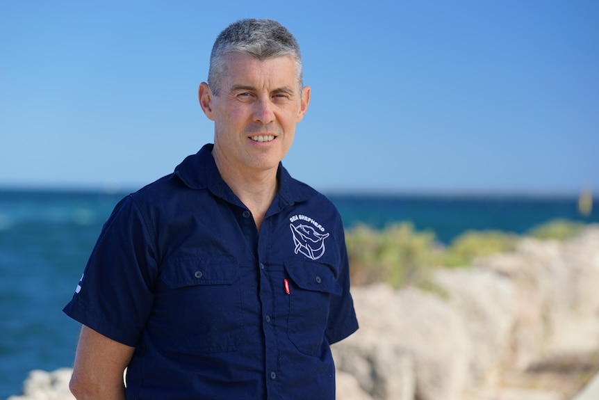 Man smiles for picture at ocean