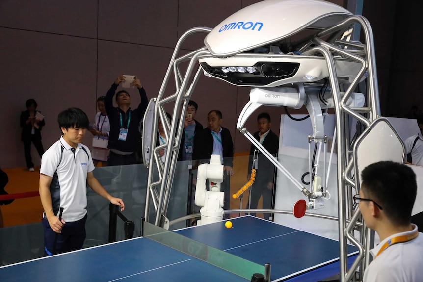 A robot plays pingpong with a human.