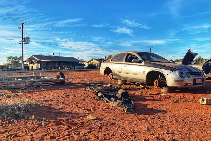 A wrecked car on the side of the road.