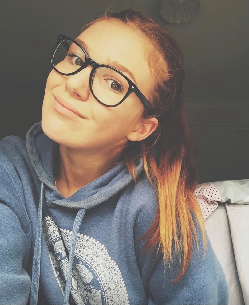 A teenage girl wearing glasses taking a selfie