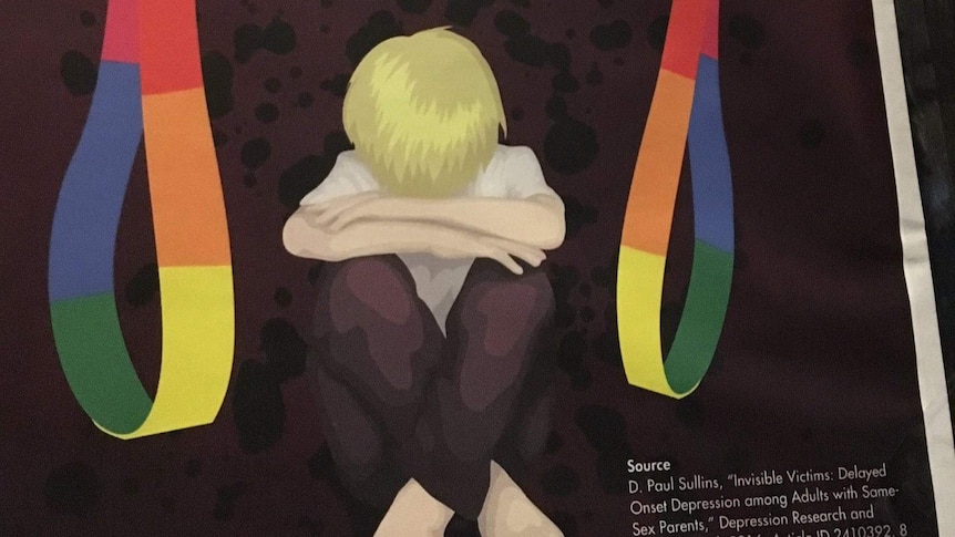 A poster with the words "stop the fags" and two hands holding rainbow coloured belts over a cowering child.