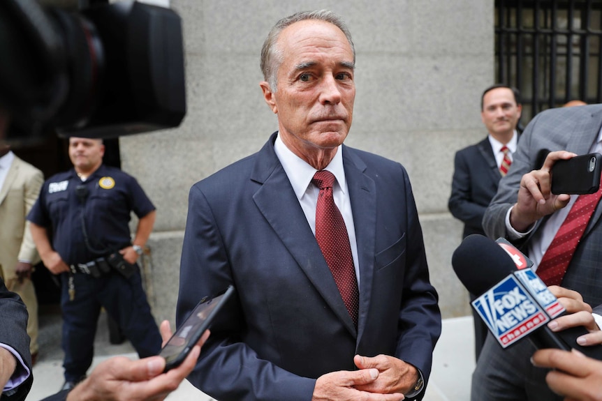 US congressman Chris Collins stands in front of reporters.