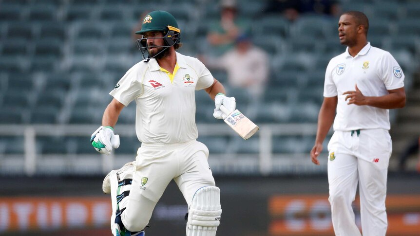 Batsman Joe Burns runs while bowler Vernon Philander stands by.