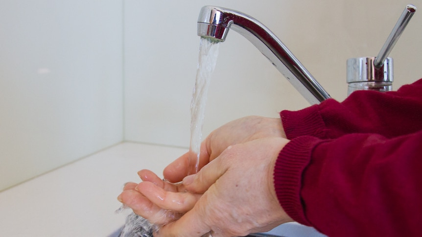 A woman washing her hands.