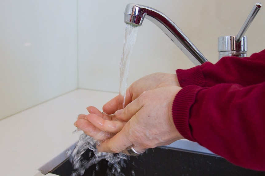 A woman washing her hands.