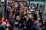 People with face masks stand close together as they wait for a subway train in Frankfurt.