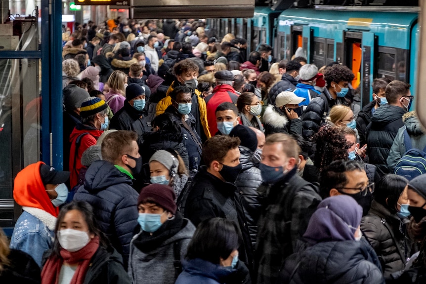 People with face masks stand close together as they wait for a subway train in Frankfurt.