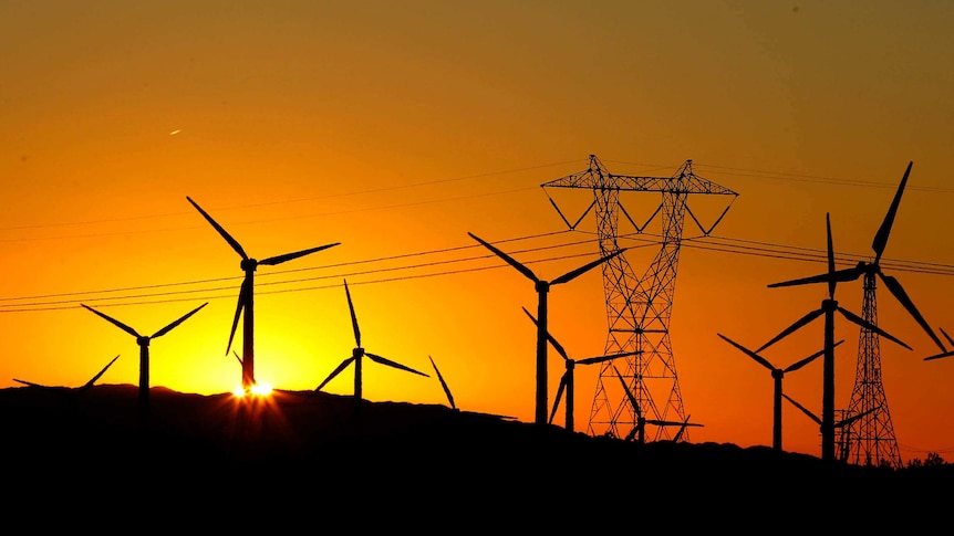 A silhouette of wind turbines at sunset.