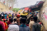 People gather around a bus wreck in a South Asian highway