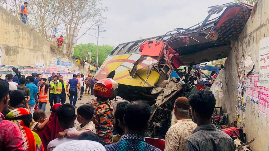 People gather around a bus wreck in a South Asian highway