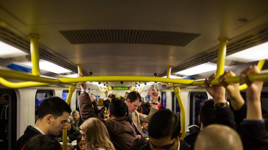 Commuters stand on Metro Train in Melbourne.