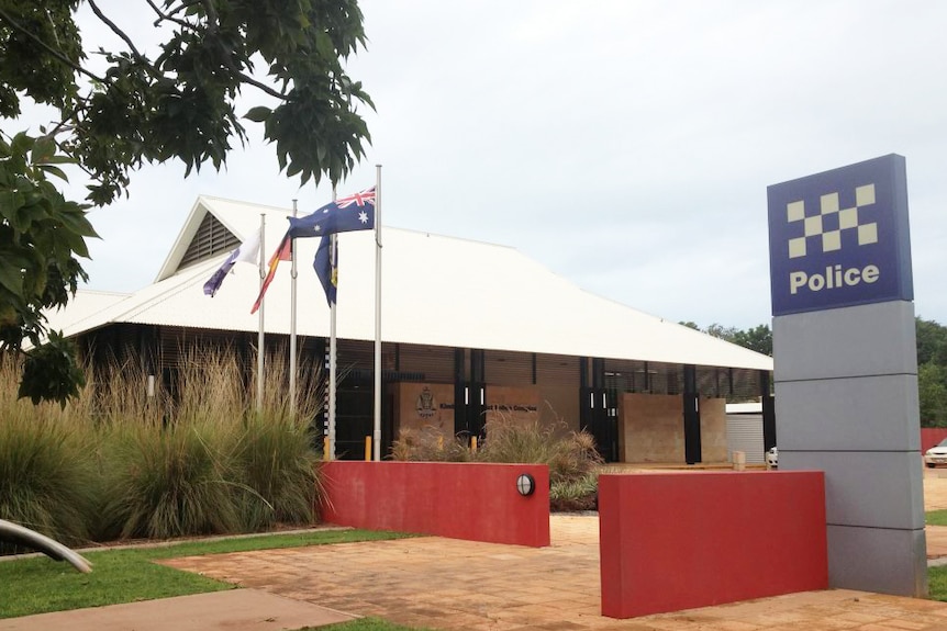 the front of the police station, with flags and lawn