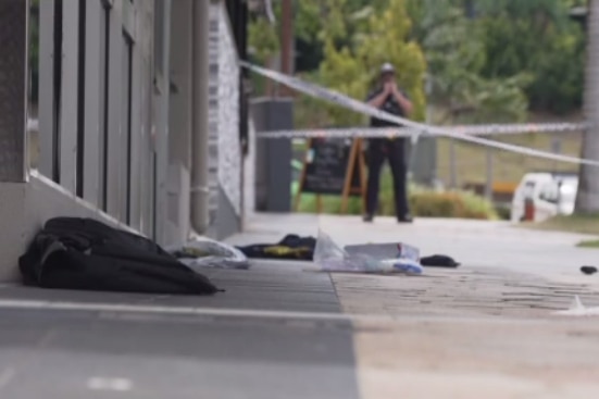 personal belongings scattered on the ground behind police tape