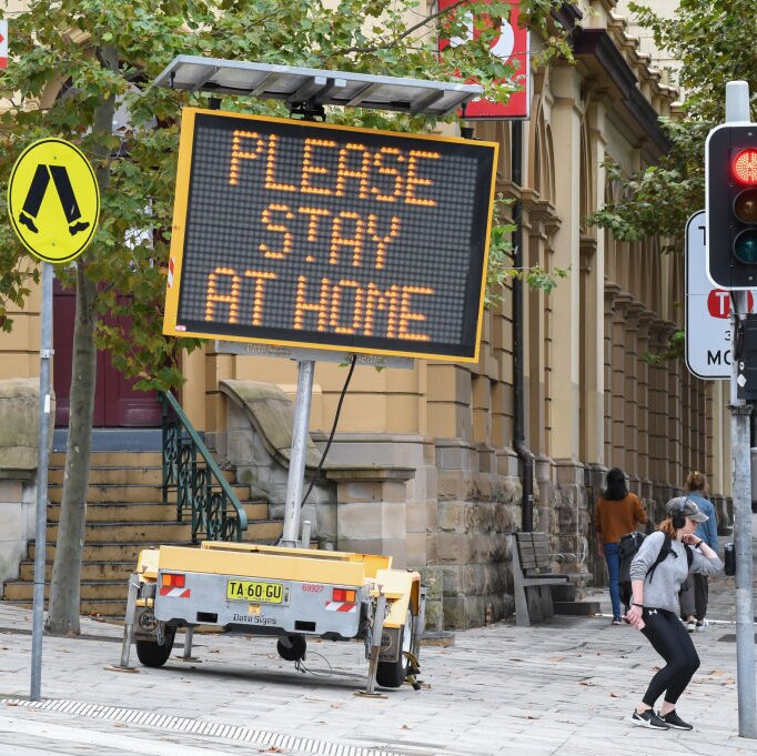 A digital sign on an inner city street corner in Sydney warns people to stay at home during the COVID lockdown.