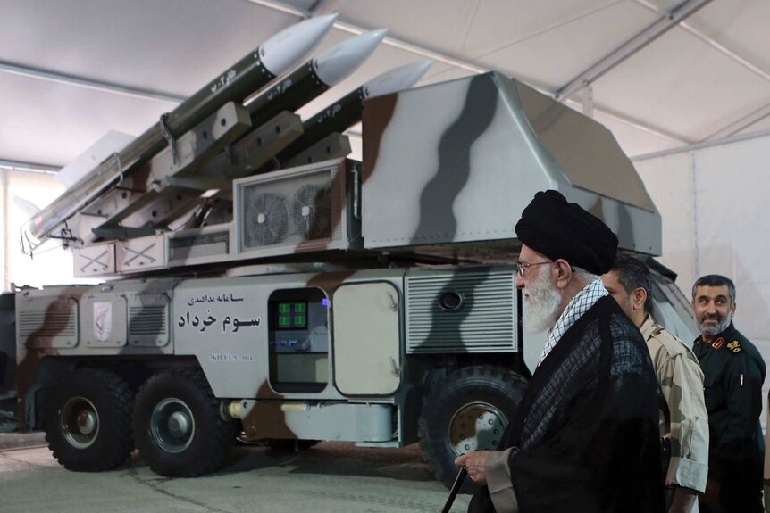 Iran's turbaned supreme leader Ayatollah Ali Khamenei inspects a truck loaded with missiles.