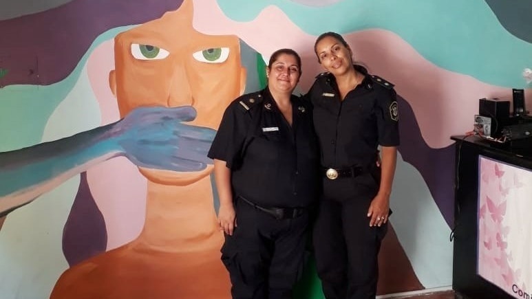 Two Argentinian police women in the station with a brightly coloured wall