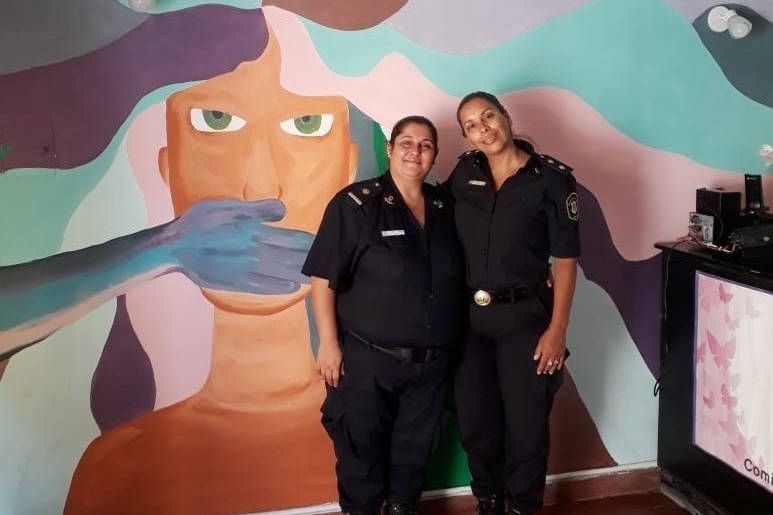 Two Argentinian police women in the station with a brightly coloured wall