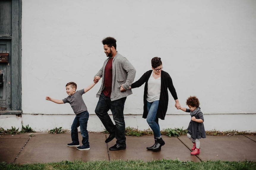 A family walking on a pavement together.