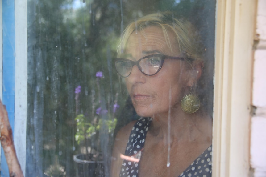 A woman stares out a window.