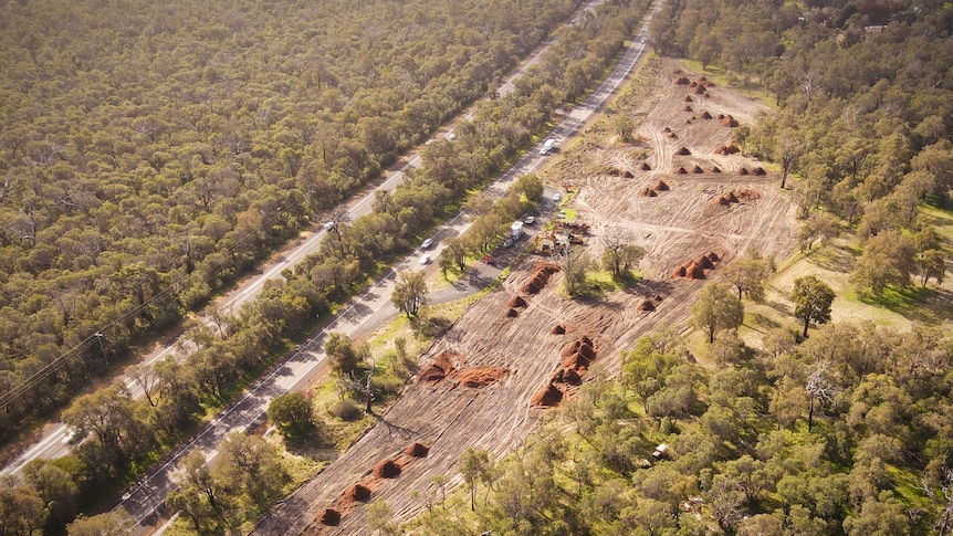 An aerial shot of cleared land next to a highway