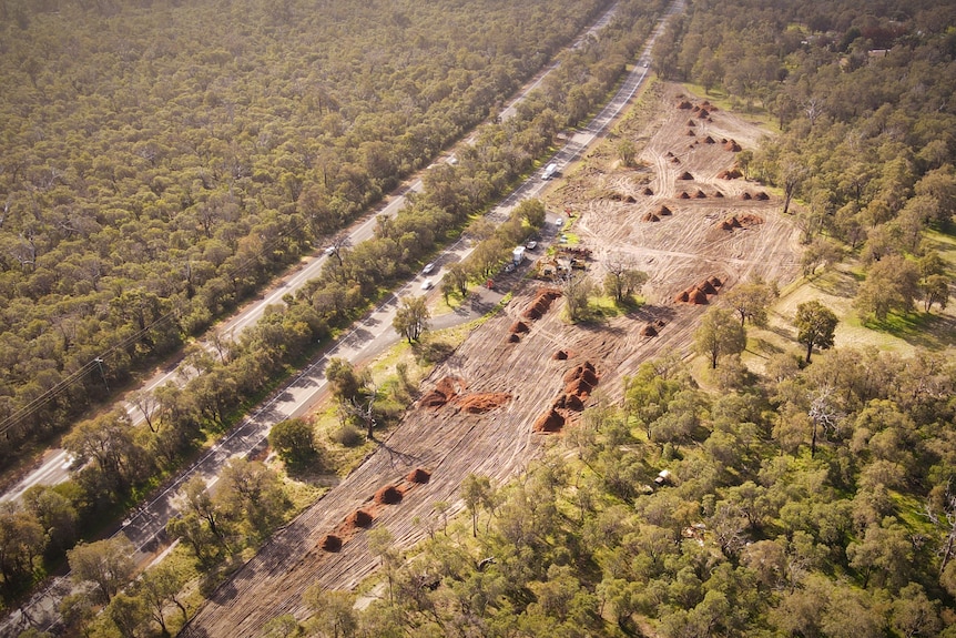 An aerial shot of cleared land next to a highway