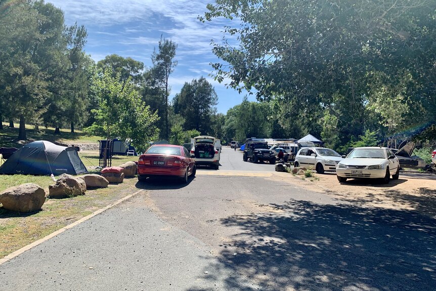 Various cars are parked along the road near the Cotter