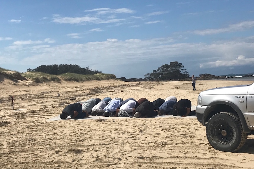 Friends and family of missing teen, Ali Mosawi, praying on the beach during the search for him.