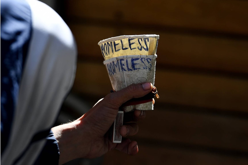 A cup with the word "Homeless" written on it.