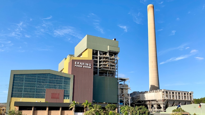 Wide shot of Origin Energy's Eraring power station with sign and smoke stack visible.