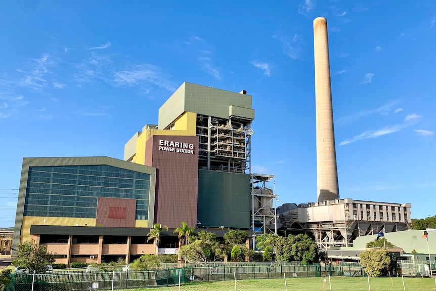 Wide shot of Origin Energy's Eraring power station with sign and smoke stack visible.