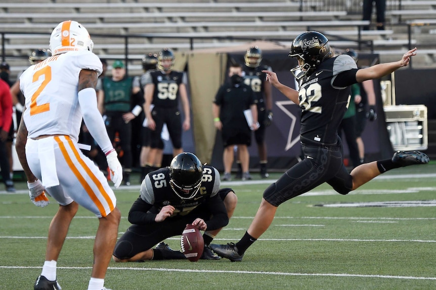 A US college place kicker runs in to kick the ball for Vanderbilt University against the University of Tennessee.