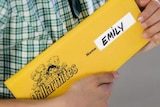 A student holds a dollarmite cheque book. 