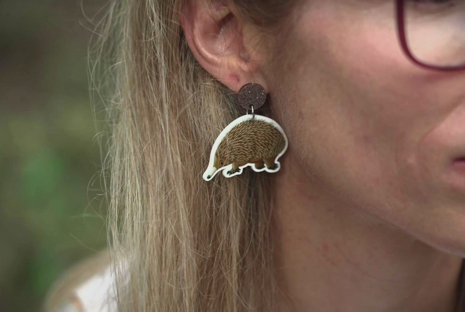 O lado da cabeça de uma mulher mostrando-a com uma orelha de equidna.