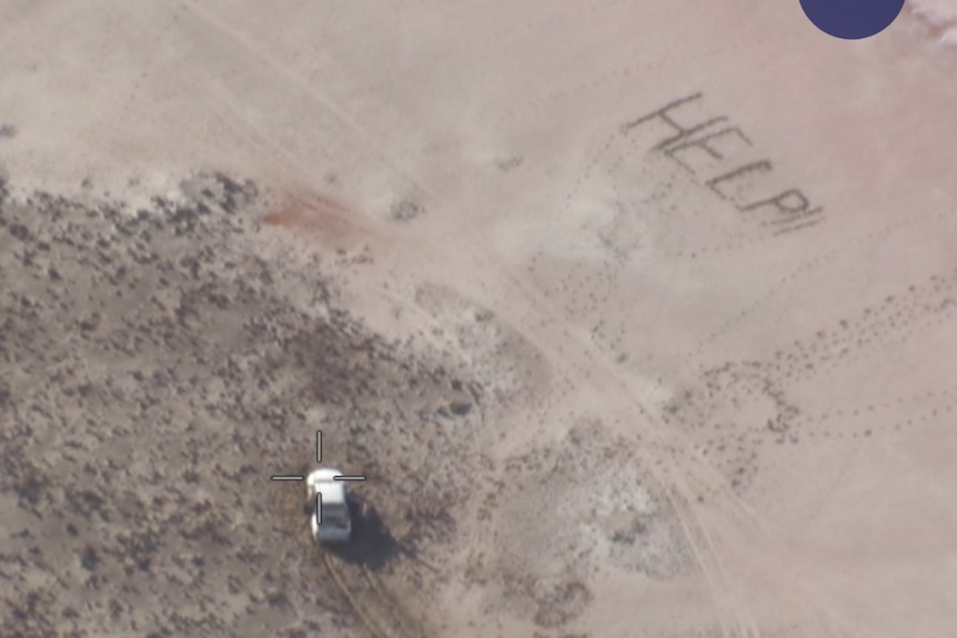 A stranded vehicle and the words HELP written in sand nearby.  