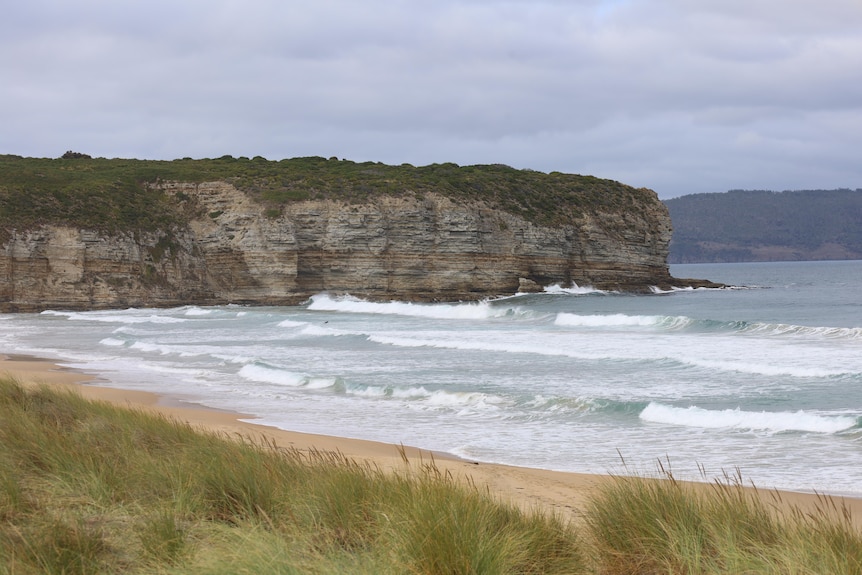 A rocky headland and waves on a beach