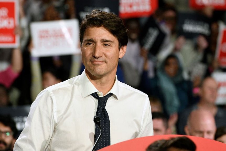 Justin Trudeau smiling surrounded by supporters