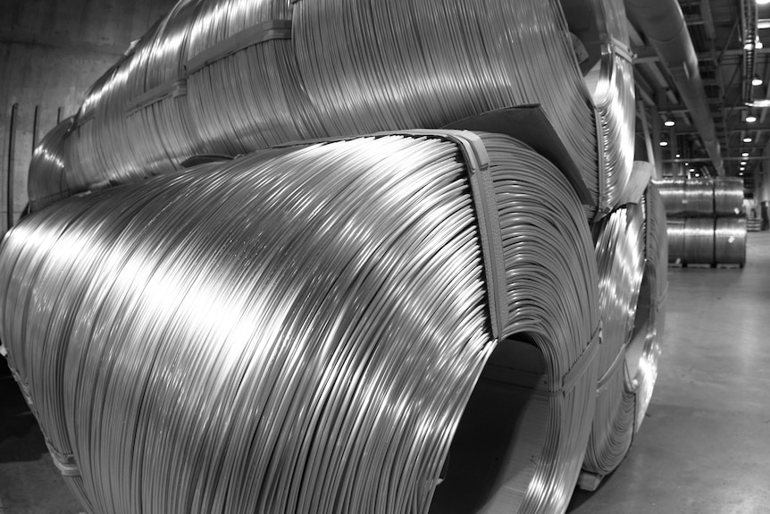 Giant rolls of coiled aluminium in a factory.
