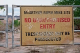 A locked gate with a large 'no unauthorised entry' sign affixed to it. 