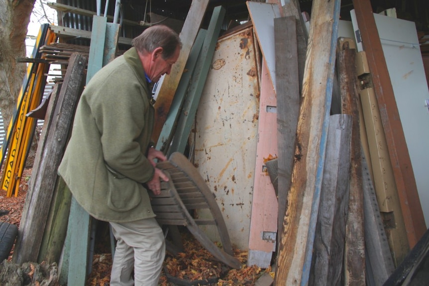 Andrew Baulch moves materials in his shed to reveal the old safe door.