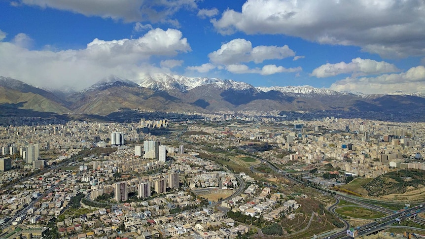 Oblique aerial shot of Tehran city, with mountains visible in background