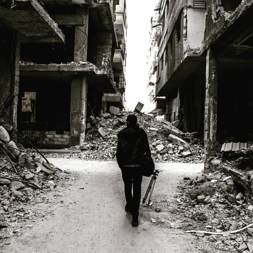 Nour Adam stands in the ruins in eastern Ghouta.