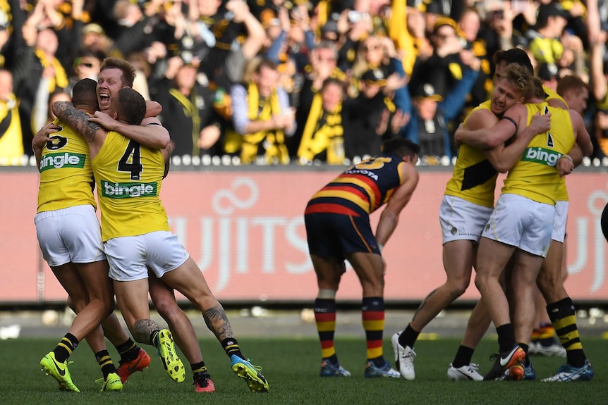 Shaun Grigg, Jack Riewoldt and Dustin Martin hug each other on the field after grand final.