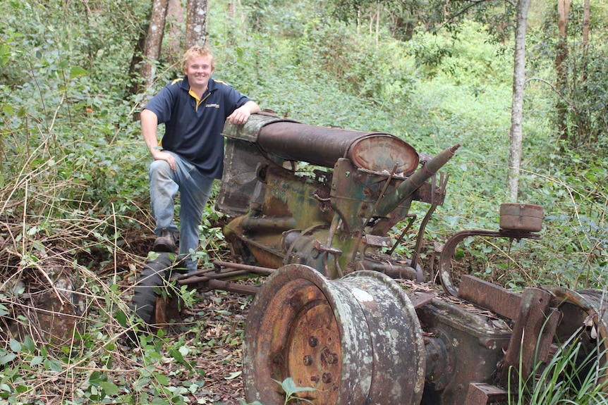 A smiling Tom Chivers leans on old gold mining equipment near Orara-Coramba gold field, May 2018